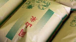 「岡山米」と赤文字で印刷された米袋のアップ。